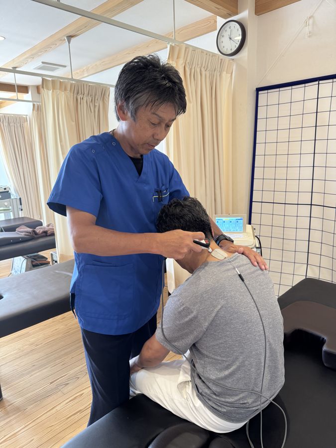 患者さまの首・肩の状態を確かめながら施術する様子